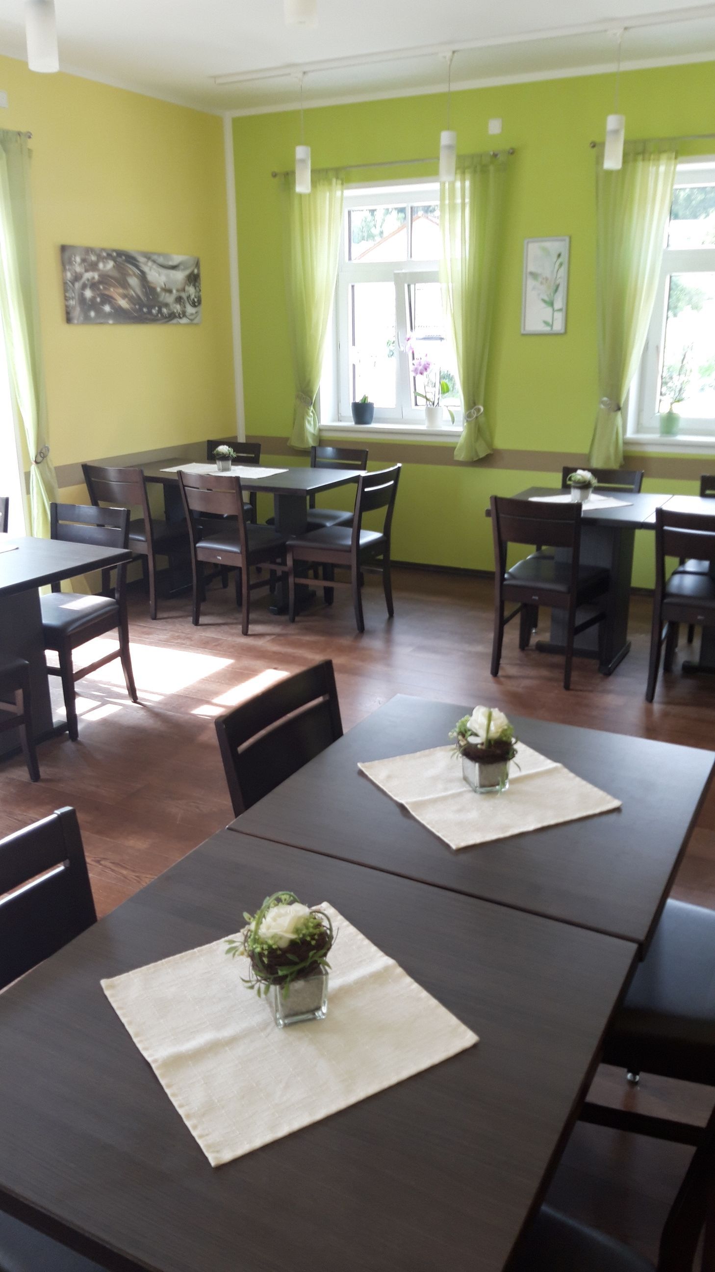 Croissants und Gebäck auf einem Gitterrost an einer Café-Theke mit gelber Speisekarte.