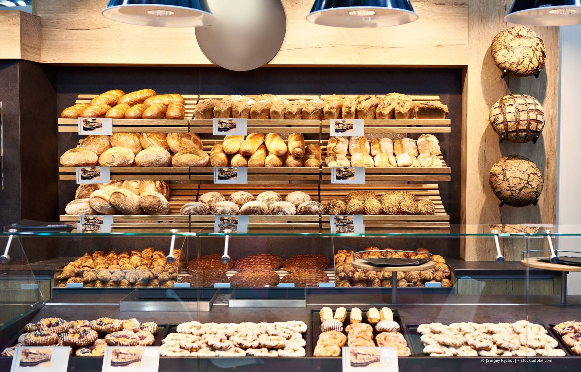 Bäckerei-Auslage mit verschiedenen Broten und Gebäcken auf Regalen und einer Theke.