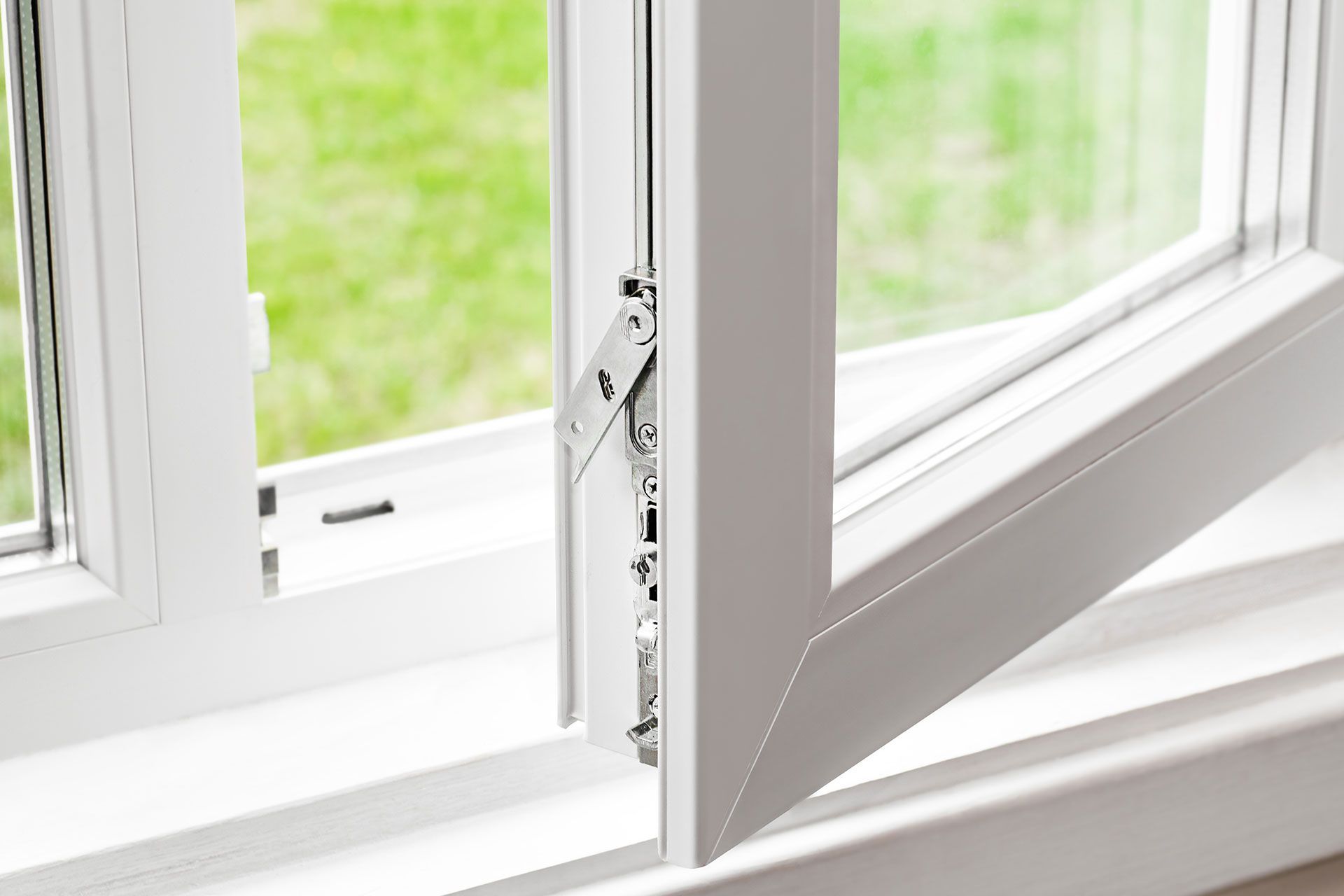 Eine Nahaufnahme eines offenen Fensters mit grünem Hintergrund.