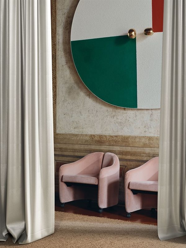 Ein Raum mit zwei rosa Stühlen und einem großen Gemälde an der Wand