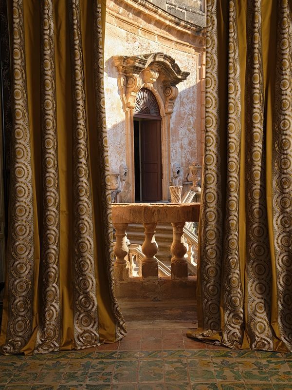 Ein Balkon mit goldenen Vorhängen mit Blick auf eine Tür