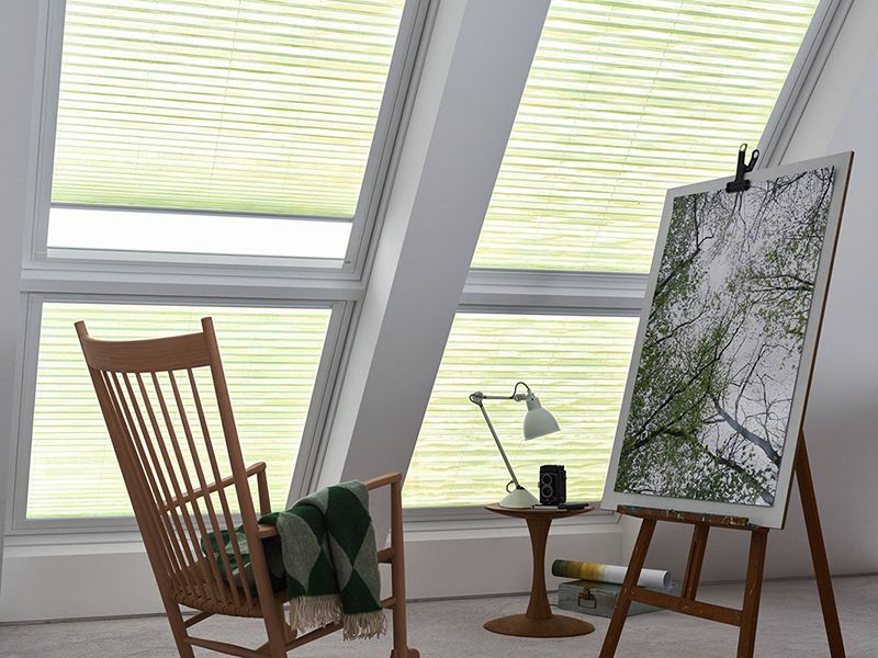 Ein Zimmer mit einem Schaukelstuhl und einem Gemälde auf einer Staffelei