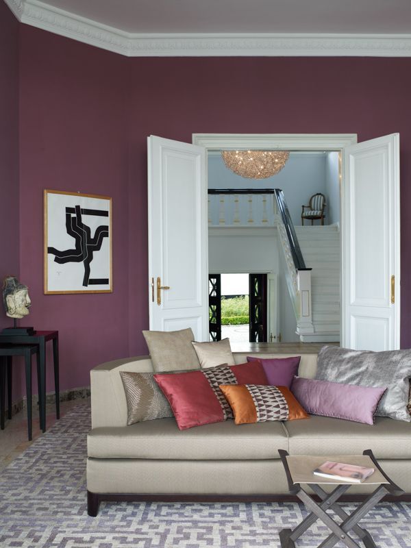 Ein Wohnzimmer mit lila Wänden und einer Couch