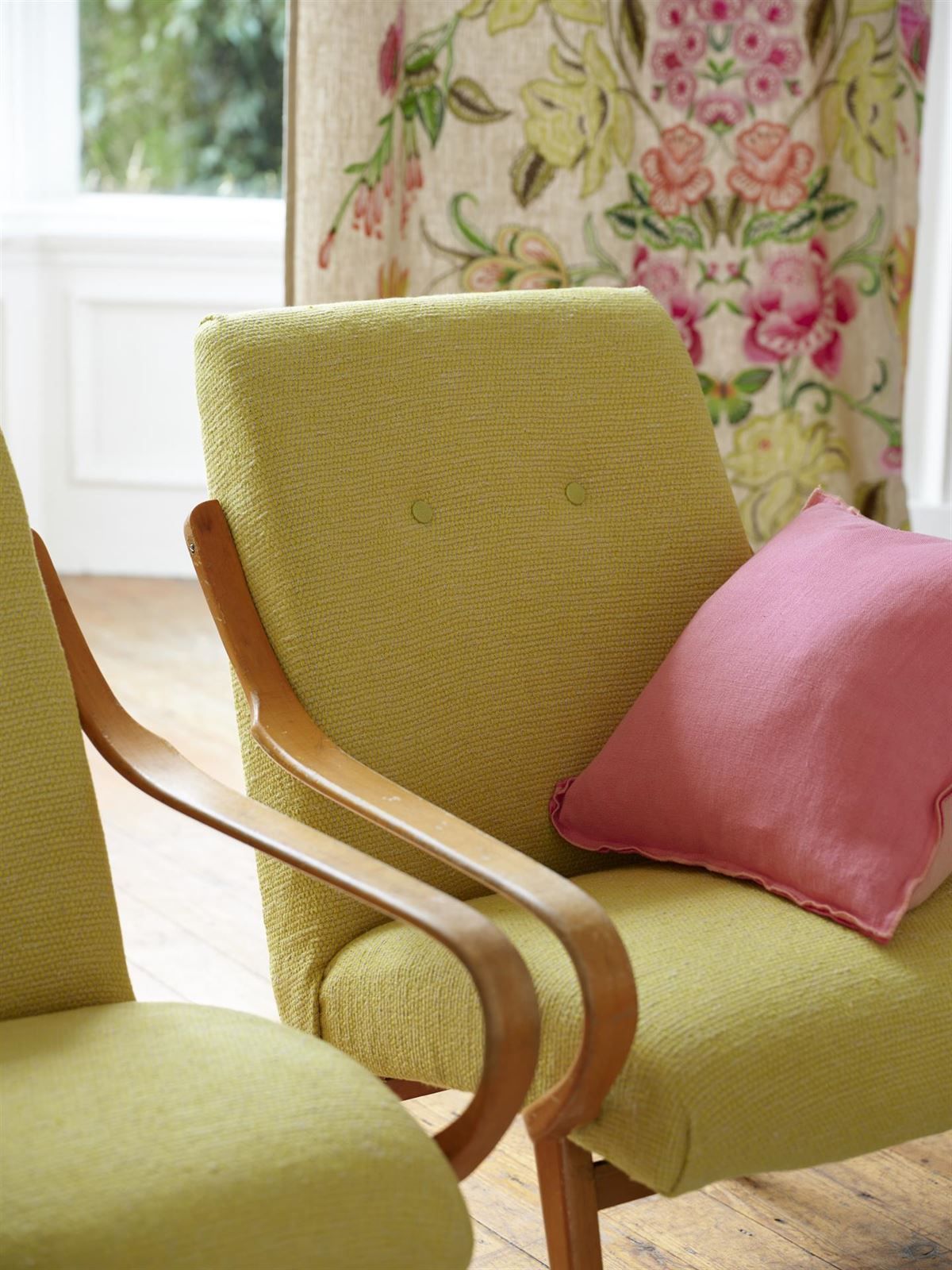 Ein grüner Stuhl mit einem rosa Kissen darauf