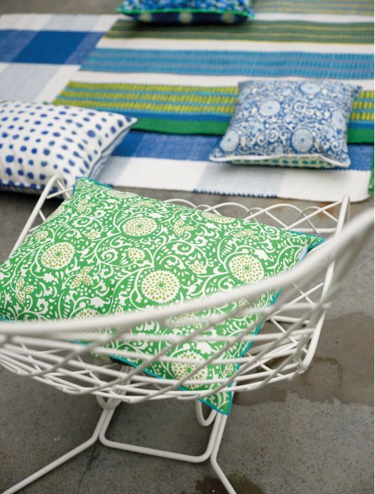 Ein weißer Stuhl mit einem grün-weißen Kissen darauf