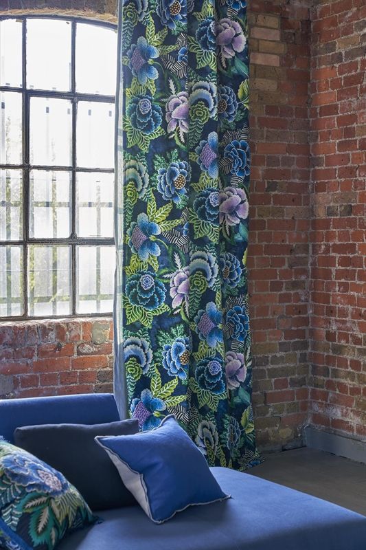 Ein Wohnzimmer mit einer blauen Couch und blauen Vorhängen