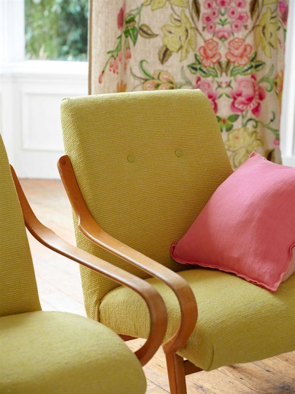 Ein grüner Stuhl mit einem rosa Kissen darauf