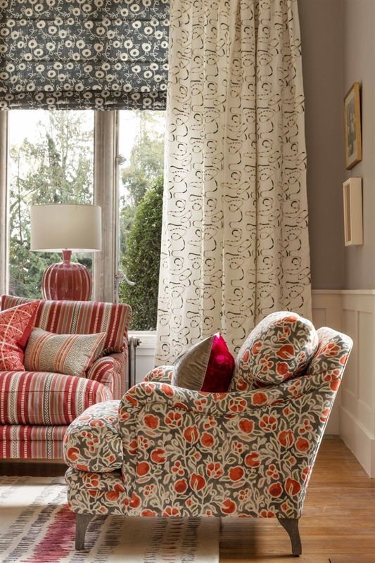 Ein Wohnzimmer mit einer Couch, einem Sessel und einer Lampe