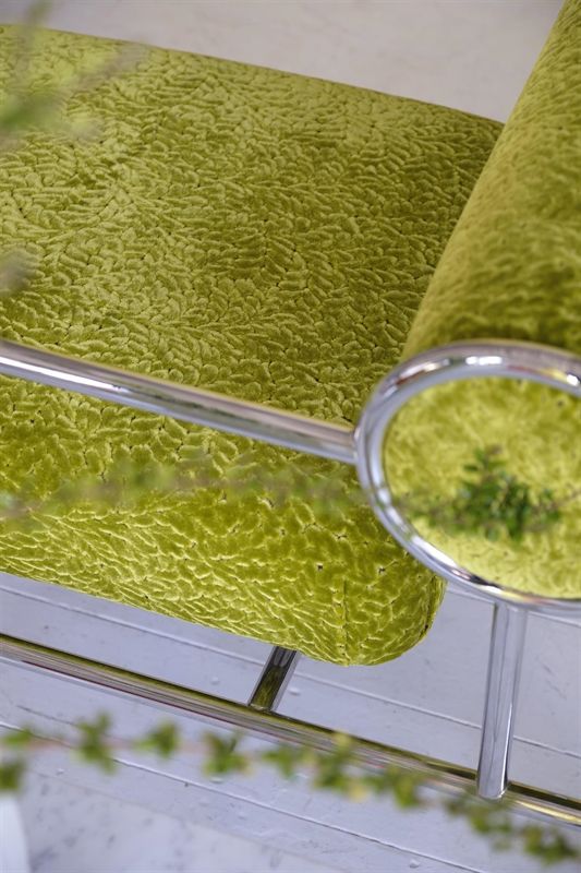 Ein Stuhl mit grünem Kissen und Chromgestell