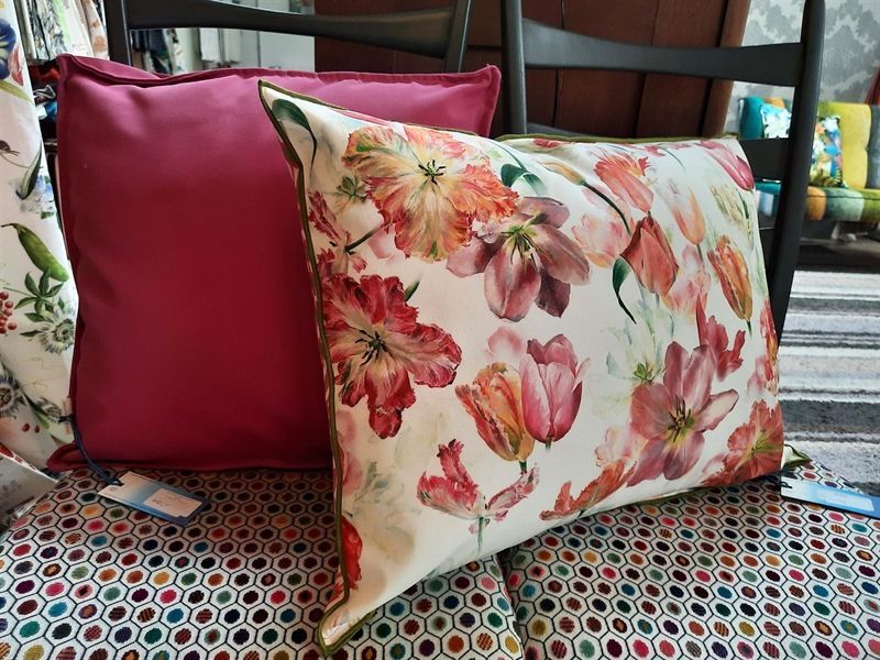 Ein Kissen mit Blumen darauf liegt auf einem Stuhl