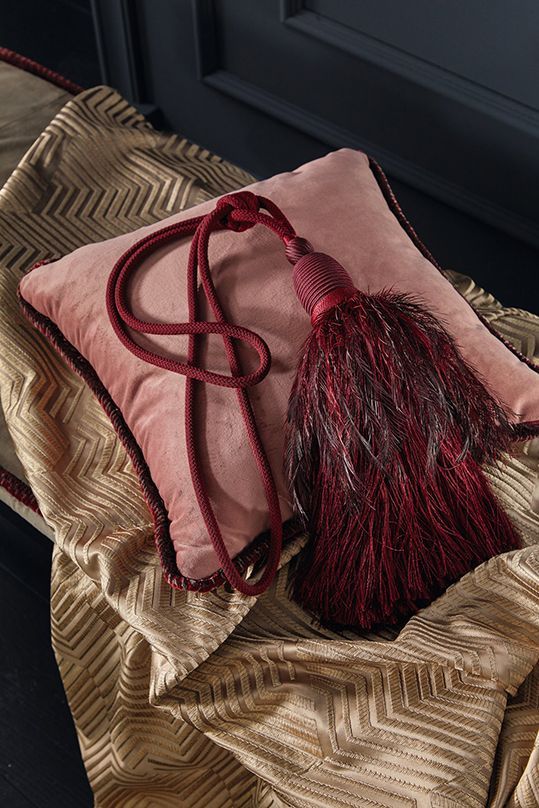 Ein rosa Kissen mit einer roten Quaste daran