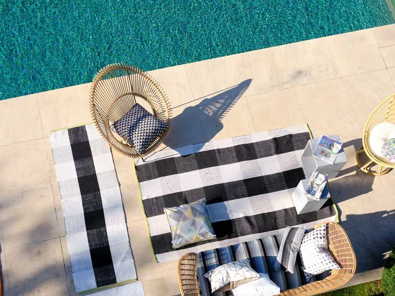 Eine Luftaufnahme eines Swimmingpools mit einem gestreiften Handtuch und Stühlen.