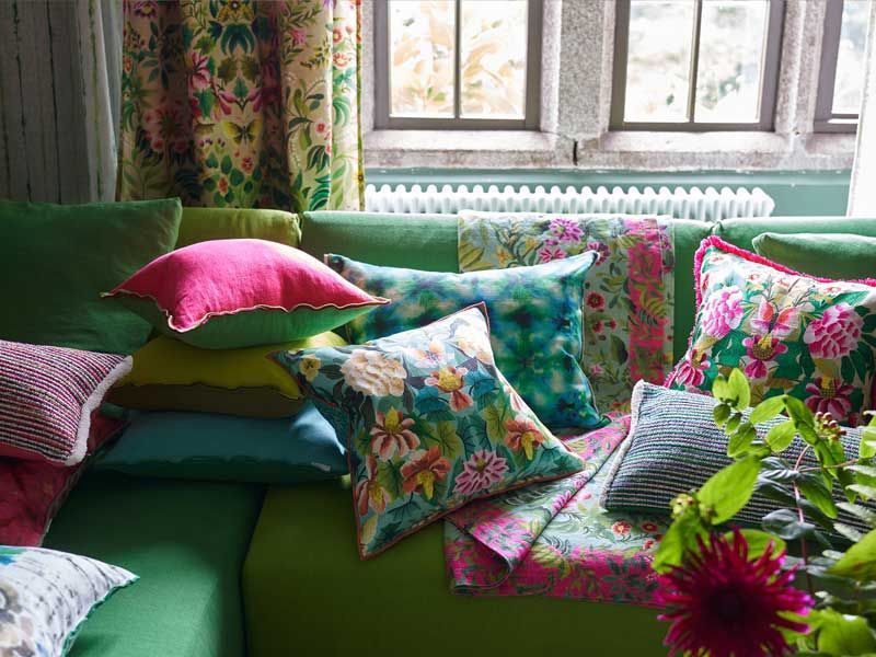 Eine grüne Couch mit vielen bunten Kissen darauf