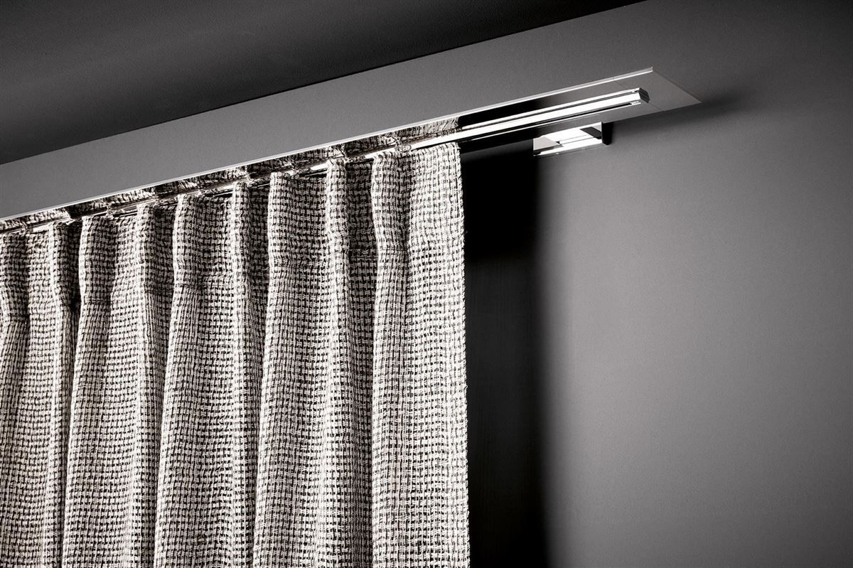 Ein schwarz-weißer Vorhang hängt an einer grauen Wand