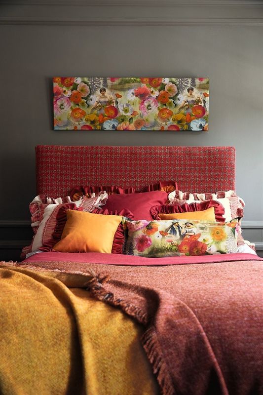 Ein Bett mit vielen Kissen und einem Gemälde an der Wand darüber