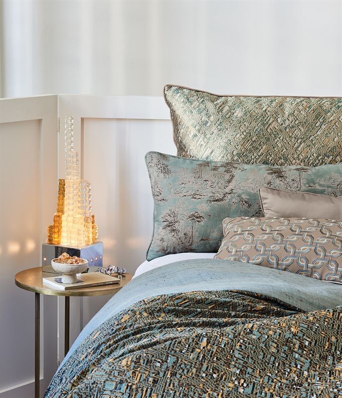 Ein Bett mit einer Decke und Kissen darauf