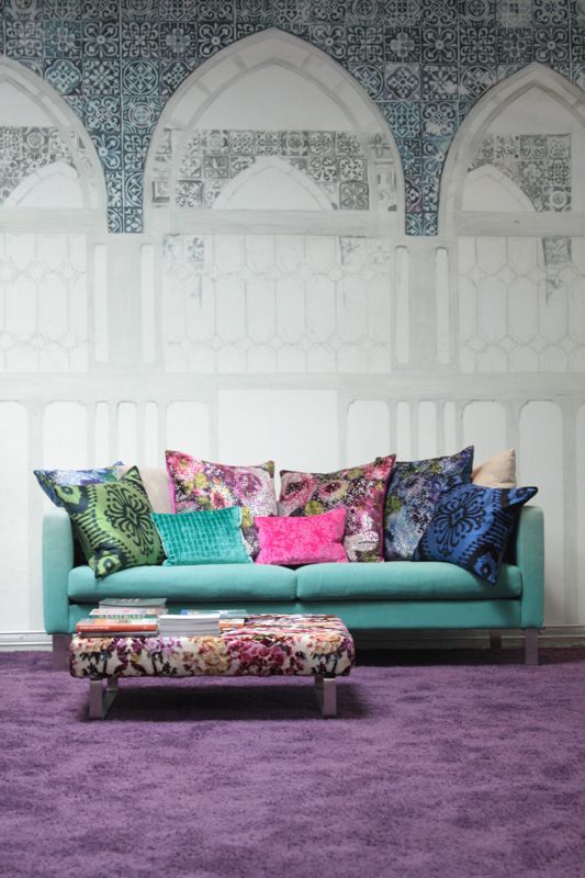 Ein Wohnzimmer mit einem blauen Sofa und einem lila Teppich