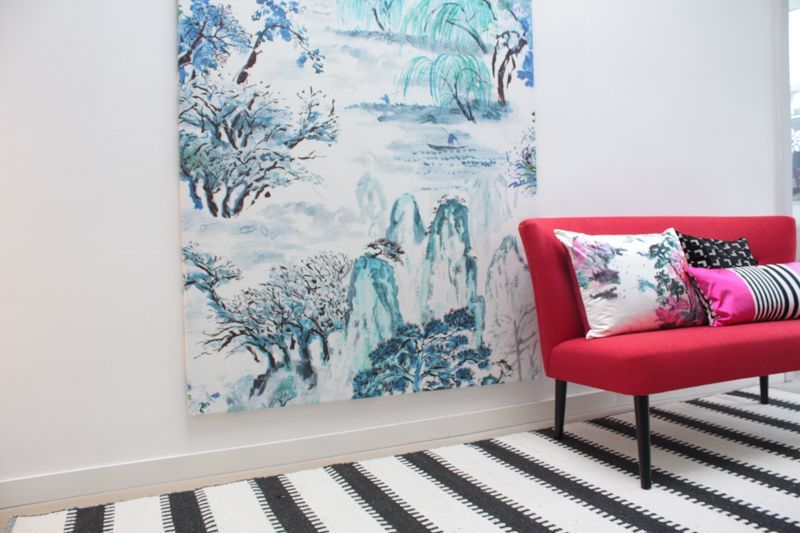 Ein Wohnzimmer mit einer roten Couch und einem großen Gemälde an der Wand