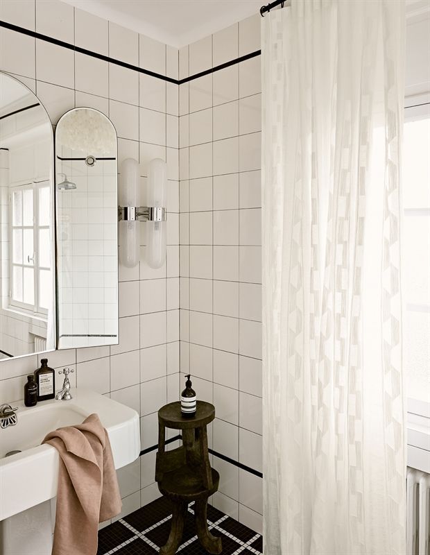 Ein Badezimmer mit Waschbecken, Spiegel und Duschvorhang