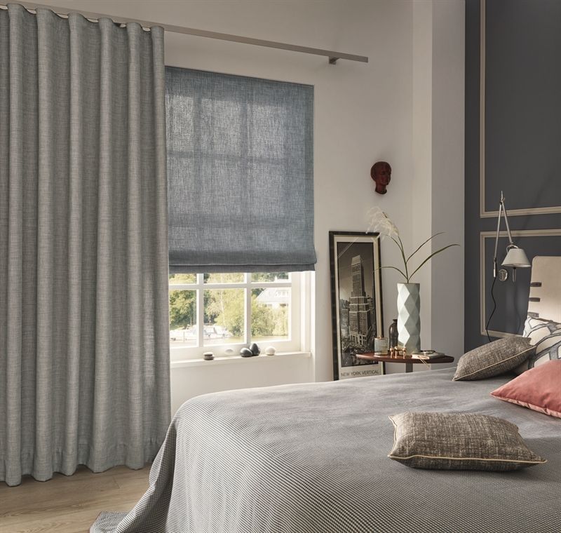 Ein Schlafzimmer mit einem Bett und einem Fenster mit Vorhängen