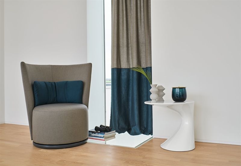 Ein Wohnzimmer mit Stuhl, Tisch und Vorhängen