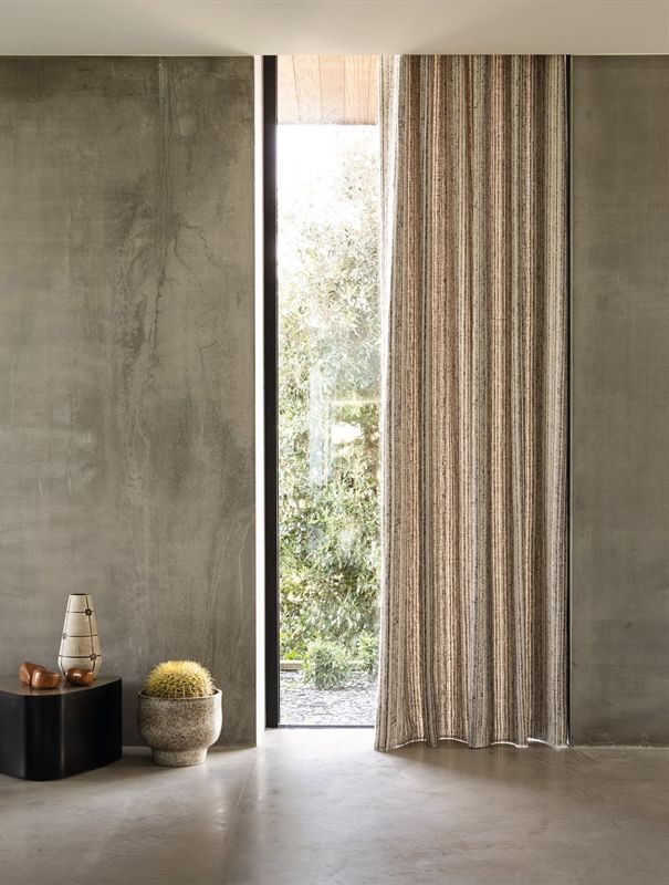 Ein Raum mit einem großen Fenster und Vorhängen