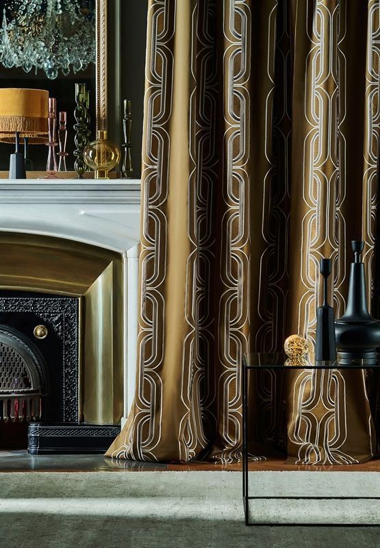 Ein Wohnzimmer mit Kamin und goldenen Vorhängen