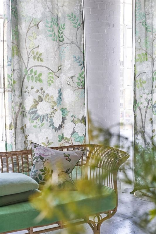 Ein Wohnzimmer mit einer grünen Couch und grünen Vorhängen