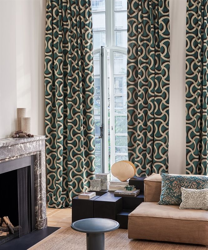 Ein Wohnzimmer mit Kamin, Couch und Vorhängen