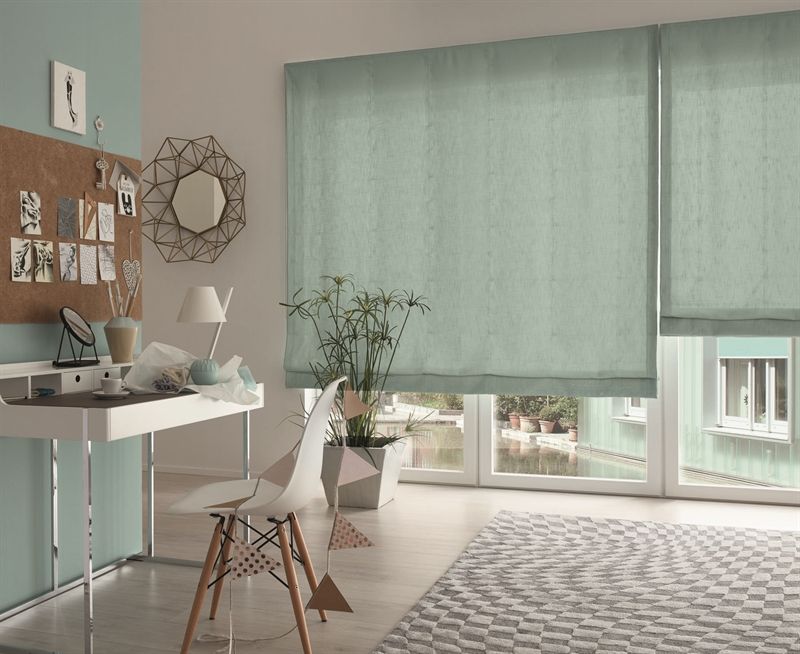 Ein Zimmer mit einem Schreibtisch, Stühlen und einem großen Fenster.