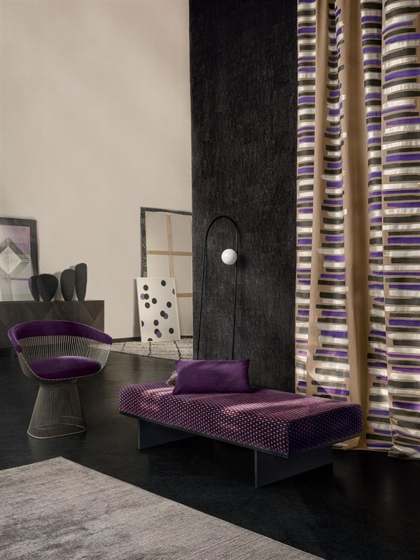Ein Wohnzimmer mit lila Möbeln und gestreiften Vorhängen