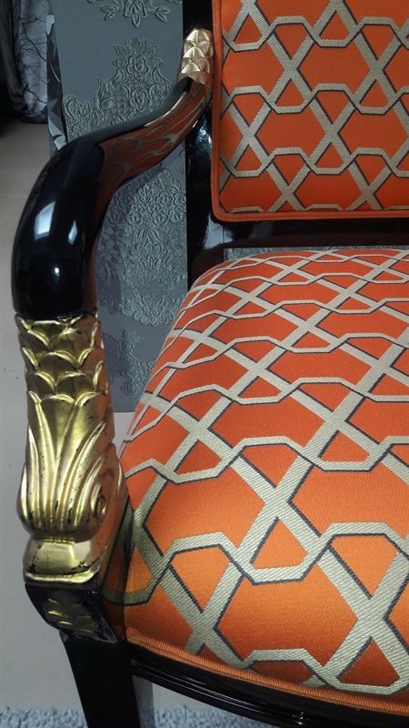 Ein Stuhl mit einem orange-goldenen Muster darauf