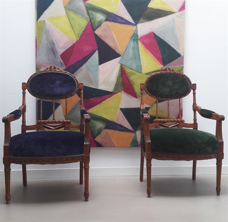 Zwei Stühle stehen vor einem bunten Gemälde