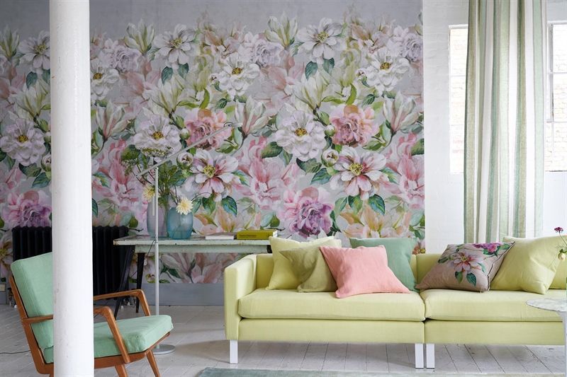 Ein Wohnzimmer mit einer gelben Couch und einer geblümten Tapete