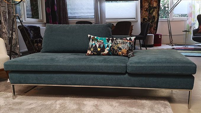 Eine blaue Couch mit einem geblümten Kissen darauf