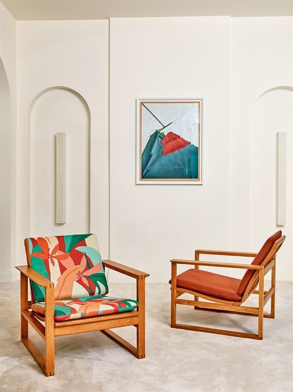 Zwei Stühle in einem Raum mit einem Gemälde an der Wand darüber