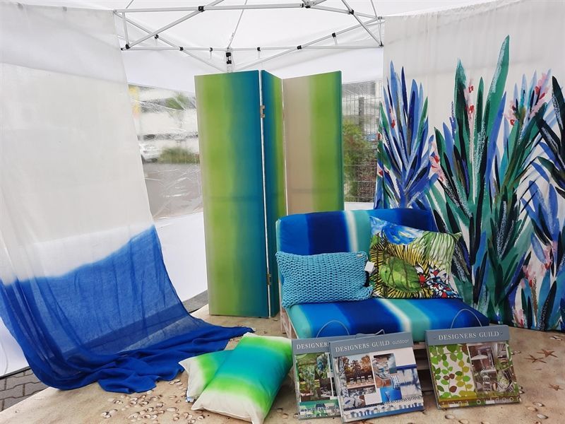 Ein blau-grünes Zimmer mit einer Couch und Kissen