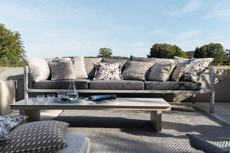 Eine Couch mit vielen Kissen steht neben einem Couchtisch