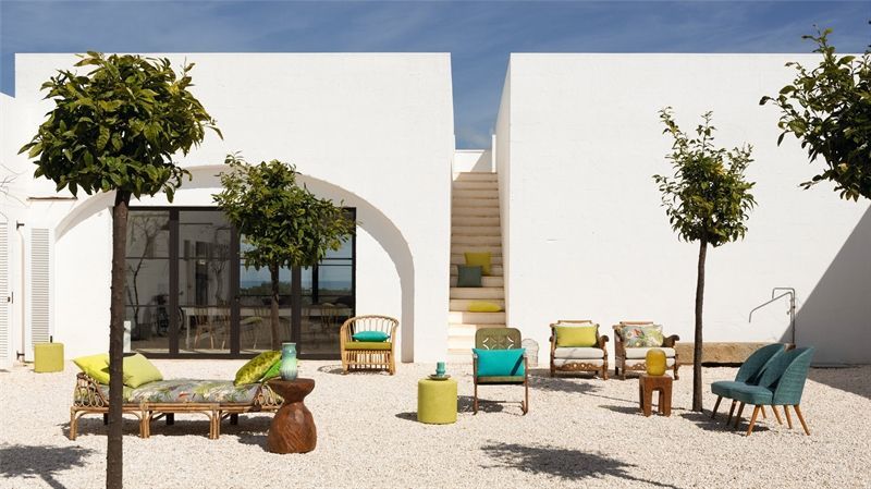 Ein weißes Gebäude mit vielen Möbeln davor