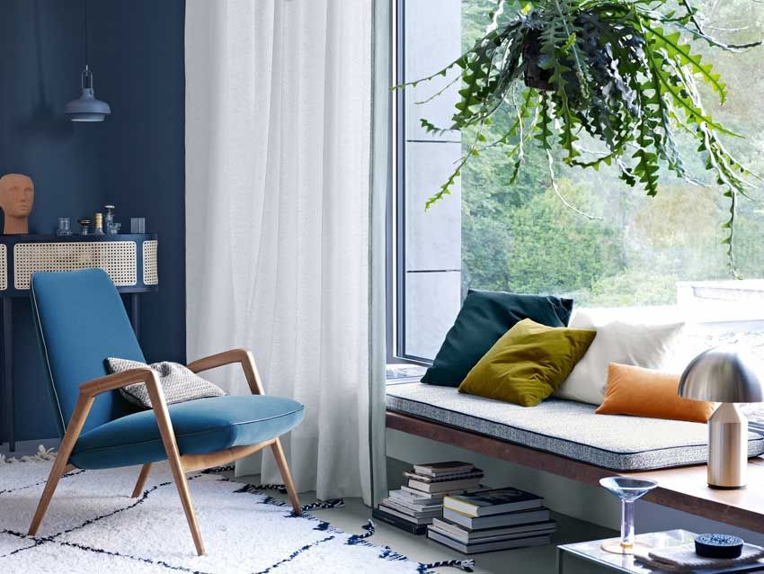 Ein Wohnzimmer mit einem blauen Sessel und einer Couch