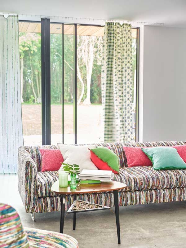 Ein Wohnzimmer mit einer bunten Couch und einem Tisch