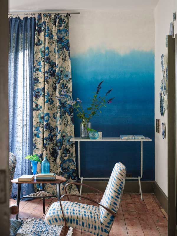 Ein Wohnzimmer mit blauen und weißen Vorhängen und einem Stuhl