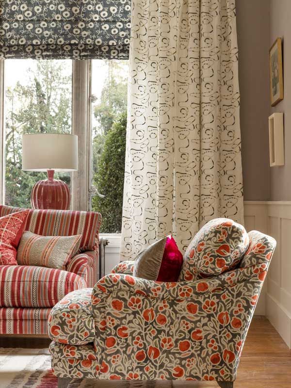 Ein Wohnzimmer mit einer Couch, einem Sessel und einer Lampe