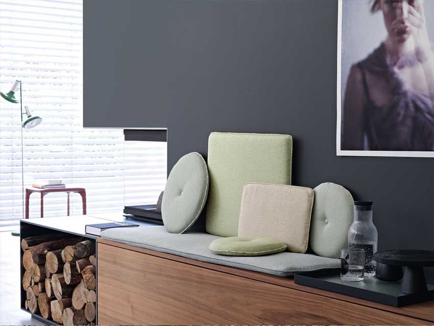 Eine Couch mit Kissen und einem Frauenbild an der Wand