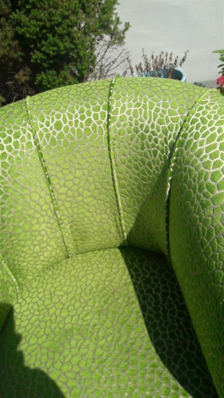 Eine Nahaufnahme eines grünen Stuhls mit Leopardenmuster.