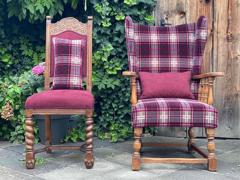 Zwei Stühle mit karierten Kissen stehen nebeneinander.
