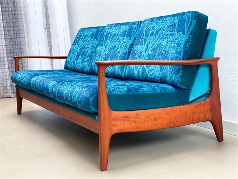 Eine blaue Couch mit Holzrahmen und blauen Kissen