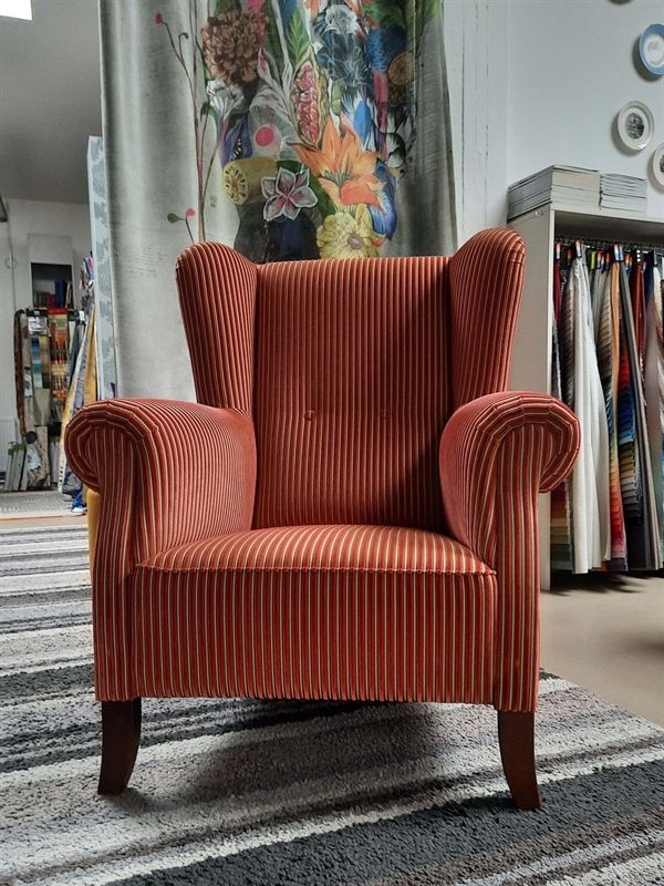 Ein rot gestreifter Stuhl steht auf einem Teppich in einem Zimmer.