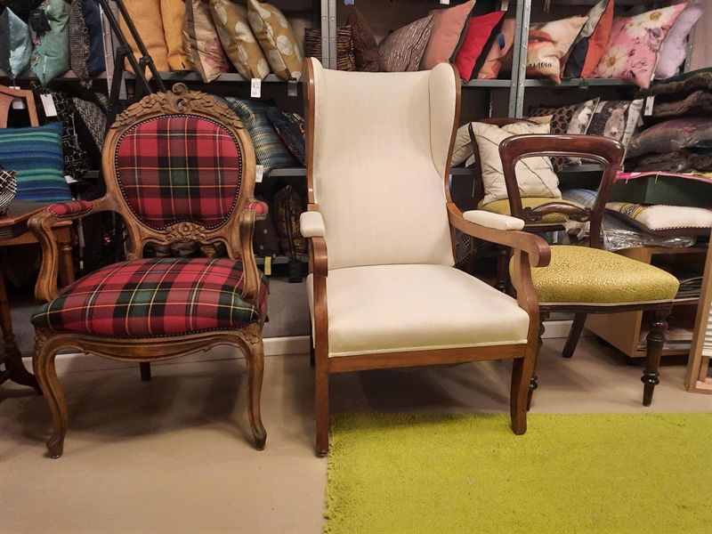 Ein Stuhl mit kariertem Sitz steht neben einem anderen Stuhl