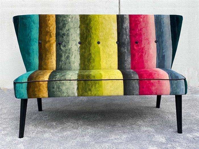 Eine bunt gestreifte Couch mit schwarzen Beinen